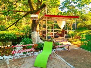 a green bench next to a tree and a pavilion at Green House in Kobuleti +9 photos