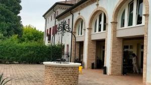a brick building with a fountain in front of it at Ranch Borgo Bellavita in Fossalta Maggiore +39 photos