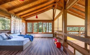 a bedroom with a bed in a wooden house at Casa Bosque Encantador in Rancho Queimado