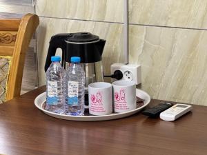 a tray with water bottles and cups on a table at Yangi Andijan Hotel in Andijan