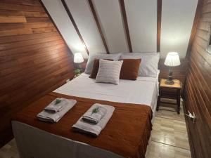 a bedroom with a bed with towels on it at Chalé Rancho Ouro Verde in Rolândia