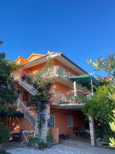 a house with a balcony and tables and trees at Apartments Lea in Orebić