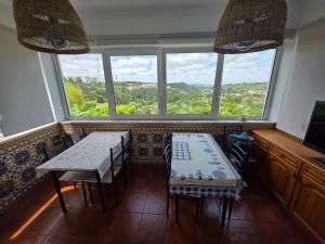 a dining room with a table and chairs and windows at Quinta da Mainça in Coimbra