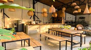 a restaurant with wooden tables and a kitchen with a counter at Aduana House in Santa Teresa Beach +22 photos