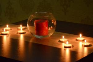 un jarrón de cristal con velas sobre una mesa de madera en Love Apartment en Vrnjačka Banja