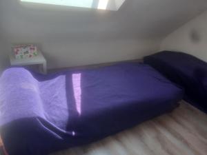 a purple bed in a small room with a table at Les LYS in Locronan +7 photos