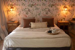 a bedroom with a large bed with flowers on the wall at Atelier Petit Hotel in Ciudad Lujan de Cuyo