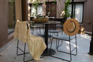 a table with chairs and a hat on a patio at Atelier Petit Hotel in Ciudad Lujan de Cuyo