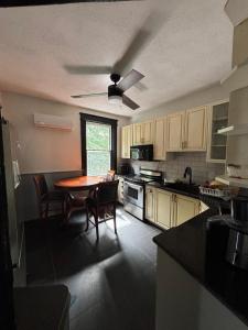 a kitchen with a table and chairs and a ceiling fan at Blue House in Halifax