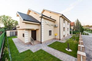 a house with a green lawn in front of it at HOTEL Villa Cvijanović - WELLNESS-SPA in Palić