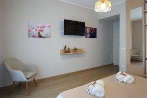 a room with a bed and a chair and a television at La Terrazza del benessere in Ferrazzano