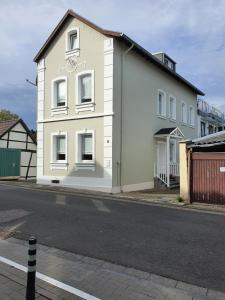 a white house on the side of a street at Friendly Home - "Helles Dachstudio" Köln Bonn Phantasialand in Bornheim