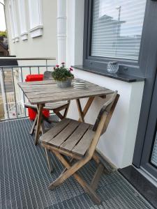 a wooden table and a chair on a balcony at Friendly Home - "Helles Dachstudio" Köln Bonn Phantasialand in Bornheim