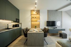 a kitchen and living room with a table and chairs at ELYX Home Apartmanok in Sárvár