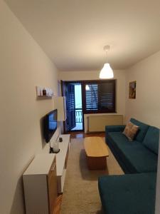 a living room with a blue couch and a tv at Lake and Forrest in Belgrade