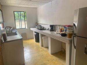a kitchen with a counter and a refrigerator at Santa Fe hostal in Santa Fe de Antioquia