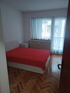 a bedroom with a red bed and a window at Lake and Forrest in Belgrade
