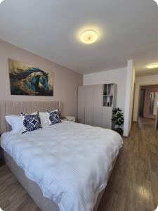 ein Schlafzimmer mit einem großen weißen Bett und blauen Kissen in der Unterkunft Smart Ghimbav in Ghimbav