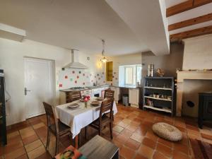 a kitchen with a table and chairs in a room at Le Gîte du Moulin in Saint-Maigrin