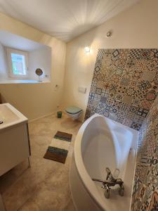 a bathroom with a tub and a toilet at Le Gîte du Moulin in Saint-Maigrin +7 photos