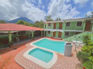 a swimming pool in front of a house at Hostal la Majada la Vida es Bella in San José La Majada