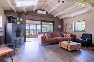 a living room with a couch and a fireplace at Chalet Achterbosch in Lieshout