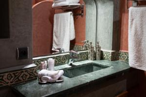 a bathroom counter with a sink and a mirror at Villa privée, 5 suites, Piscine & Jardin XXL in Marrakesh +79 photos