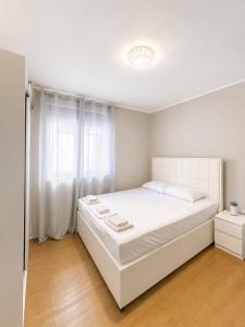 a white bedroom with a large bed and a window at Grifon 72 Apartments in Prčanj +28 photos