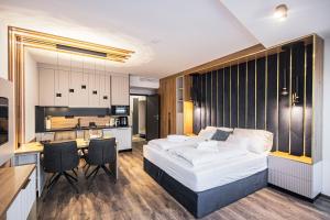 a bedroom with a bed and a desk and a kitchen at ELYX Home Apartmanok in Sárvár +39 photos