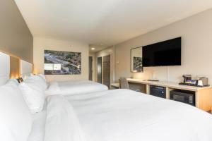 a hotel room with two beds and a flat screen tv at The Inn at Riverwalk in Edwards