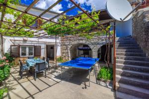 a patio with a ping pong table and a brick wall at House Katica in Grižane