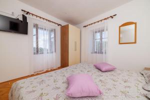 a bedroom with a bed with two pillows on it at House Katica in Grižane +35 photos