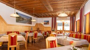 a restaurant with white tables and chairs and lights at Aparthotel Ramsau in Ramsau am Dachstein