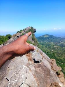 a person holding their hand on top of a rock at The Off Road Homestay in Kandy