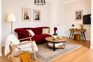 a living room with a red couch and a table at Onder de Beukenboom in Nieuwe Pekela