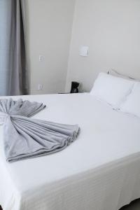 a white bed with a towel on top of it at Suite Areal in Atins