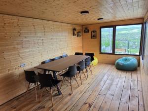 a table and chairs in a room with a large window at Gemini Cottage in Dusheti in Dushetʼi