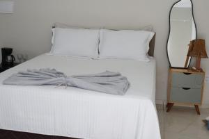 a bedroom with a white bed with a bow on it at Suite Areal in Atins