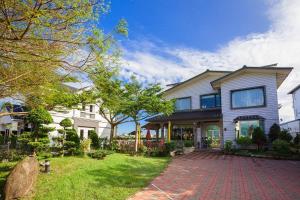 a large house with a brick driveway in a yard at Chun Feng Cao Tang Homestay in Yuanshan