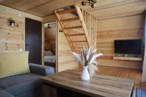 a living room with a staircase and a vase on a table at Gemini Cottage in Dusheti in Dushetʼi