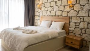 a bed in a room with a stone wall at Canata Çeşme in Çeşme