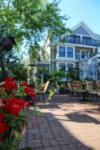 a house with chairs and a patio with red flowers at Waterford Inn Provincetown in Provincetown
