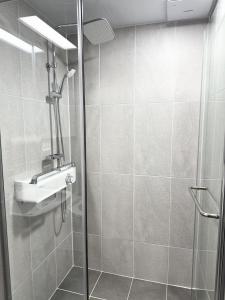 a shower with a sink and a glass shower door at Yangyang Surfing Beach 19 in Saetchak
