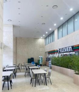a restaurant with tables and chairs in a building at Yangyang Surfing Beach 19 in Saetchak