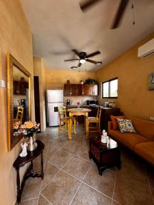 a living room and kitchen with a couch and a table at Casa San Jerónimo Departamentos in Todos Santos