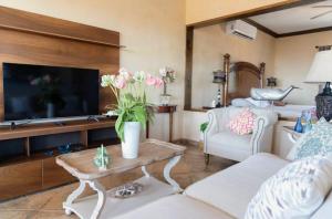 a living room with a couch and a tv at Casa San Jerónimo Departamentos in Todos Santos