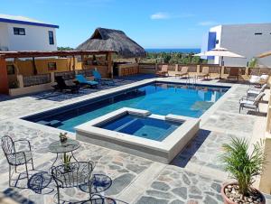 a swimming pool with chairs and a table next to it at Casa San Jerónimo Departamentos in Todos Santos