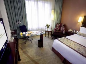 a hotel room with a bed and a table with food on it at Grand Mercure Beijing Central in Beijing