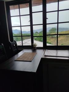 a room with a table and windows with a view at Apartaestudio confortable 1 en Combia in Pereira