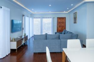 a living room with a blue couch and a table at KoKo Beach - Wooden Green House in Vila Praia Do Bilene